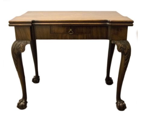 A George III mahogany games table of Chippendale design, circa 1760, fold-over green baize lined top with four wells, single 