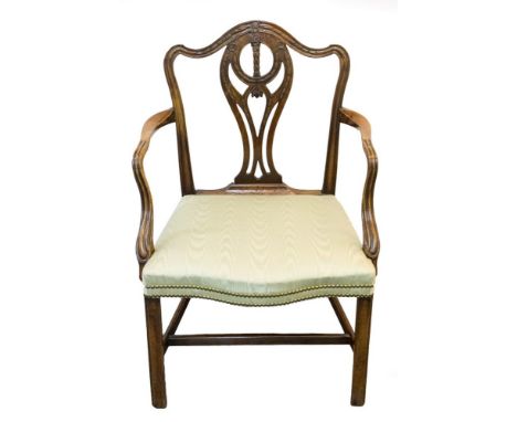 A George III mahogany armchair of Hepplewhite design, serpentine top rail with moulded swags, fret carved vase splat, inverte