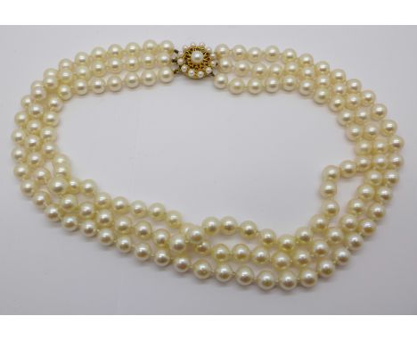 A three strand pearl necklace with gold clasp