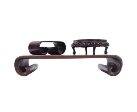 A group of three Chinese carved hardwood stand dating from the 19th Century to include a large stand on two scroll legs, a pi