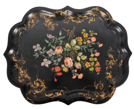An 18th Century Chinese black lacquer export papier mache tray of scalloped form. Central painted floral spray with inset mot