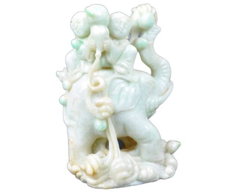 A 19th Century Chinese carved jade figurine depicting an elephant with child seated on back. The elephant raised on scrolled 