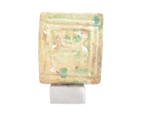 A Chinese Ming Dynasty pottery glazed tile of square form. Light green spinach glaze with central figural depicting within st