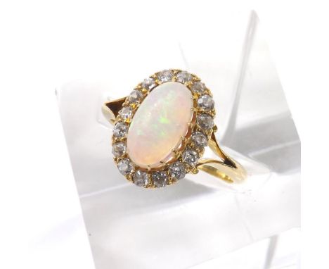 Attractive opal and diamond oval cluster ring in a yellow gold setting, the cabouchon opal in a surround of old-cut diamonds,