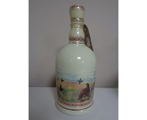 A Famous Grouse Scotch Whisky Highland decanter gilded with 24ct gold. 70 cl, sealed 