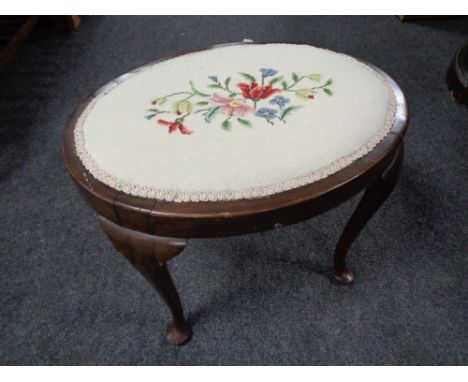 An oval tapestry upholstered dressing table stool on cabriole legs 
