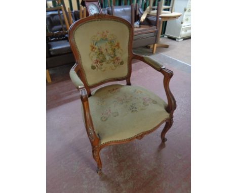 A beech framed French style salon armchair upholstered in a tapestry fabric 