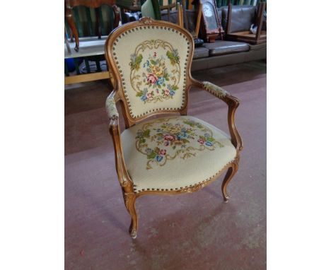 A beech framed French style salon armchair upholstered in a tapestry fabric 
