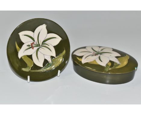 TWO PIECES OF MOORCROFT POTTERY, in the Bermuda Lily pattern, comprising an oval trinket box and a circular pin dish, each tu