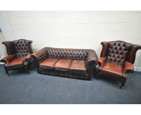 AN OXBLOOD LEATHER THREE PIECE CHESTERFIELD SUITE, comprising a three seater sofa, with buttoned back and armrests, length 19