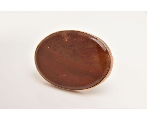 AN EARLY 20TH CENTURY HARDSTONE BROOCH, the oval agate panel within a plain polished surmount, stamped 9ct, length 45mm, appr