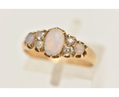 A YELLOW METAL OPAL AND DIAMOND RING, set with a central oval opal cabochon, flanked with four rose cut diamonds and two furt