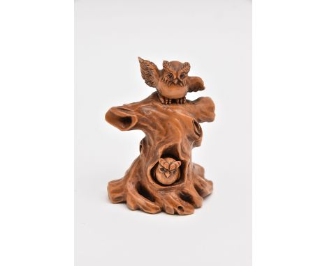 A NETSUKE, carved wood depicting two owls in a tree, one owl moves in and out of the tree, approximate height 52mm, signed to