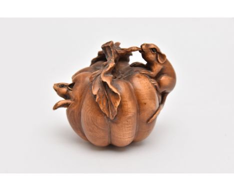 A NETSUKE, a carved wooden netsuke, depicting a pumpkin with two mice, one mouse moves in and out of the pumpkin, approximate