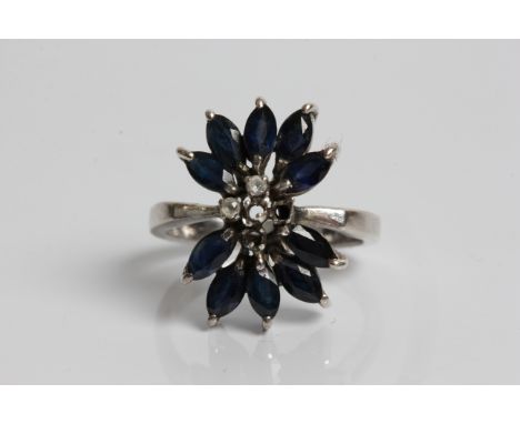 A white gold sapphire and diamond cluster ring, marked 18k, ring size K1/2, approx weight 4.43gms. Important: Online viewing 