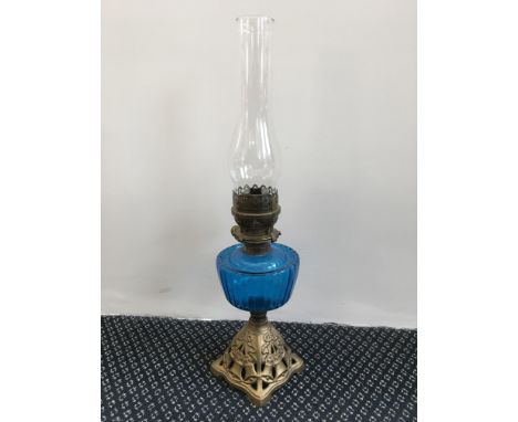 A cast iron base oil lamp with blue glass reservoir, height 54cm. IMPORTANT: Online viewing and bidding only. Collection by a