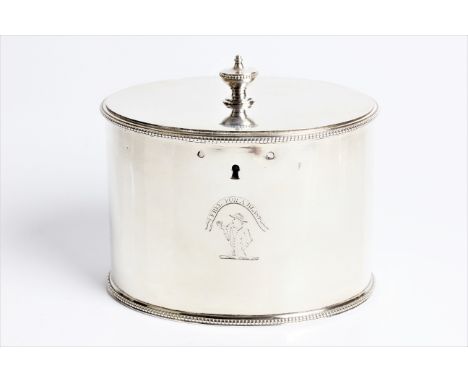 A George III silver tea caddy of plain oval form with urn finial to top, lock and original key, with engraving to front of a 