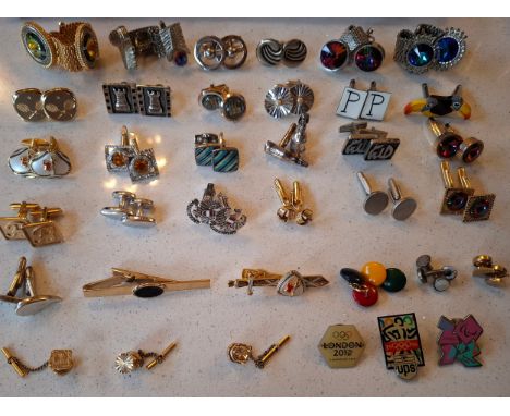 A quantity of late 20th Century cufflinks, tie pins and clips and Olympic pin badges to include a pair of silver tone Duchamp