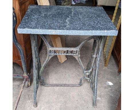 A garden table with a cast iron singer sewing machine base with a granite top 75 H x 59.5 W Location: R con If there is no co