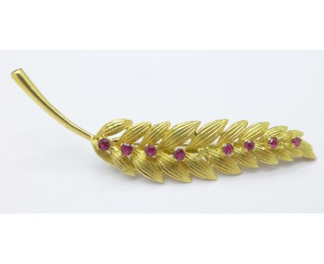 An 18ct gold and ruby brooch, set with eight rubies, lacking one, 8.9g, 68mm