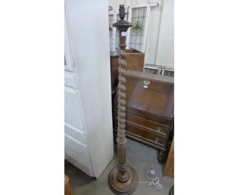An early 20th Century carved oak barleytwist standard lamp and another standard lamp 