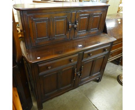 An Ercol dark elm court cupboard, corner cabinet and a nest of tables 