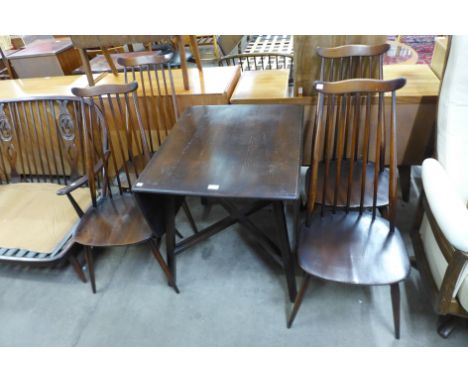 An Ercol dark elm drop-leaf table and four Goldsmith chairs 