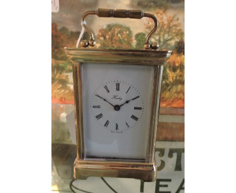 A lacquered brass carriage timepiece the rectangular enamel dial marked Henley England