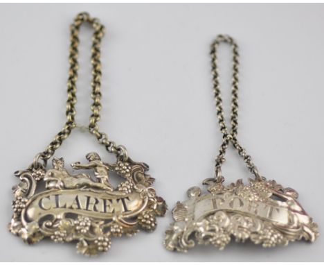 Two early 19th Century silver claret and port decanter labels each cast with cherubs among fruiting vines, larger 6cm