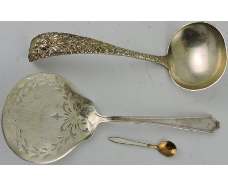 A Continental white metal pierced serving spoon, an American white metal sauce ladle, and an enamel condiment spoon