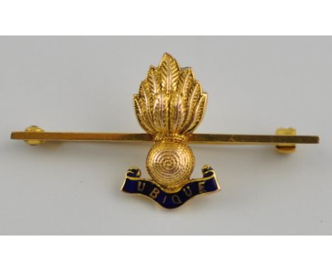 A 9ct Grenadier badge of customary form with enamel motto 