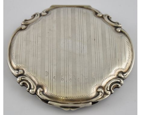An early 20th Century French engine turned and floral engraved circular compact with cast c-scroll border and mirrored interi