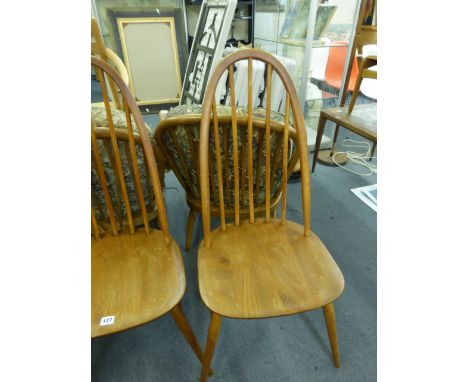 A set of four Ercol elm and beech spindle back dining chairs CONDITION REPORT: Heavy wear, scratches and scuffs but structura