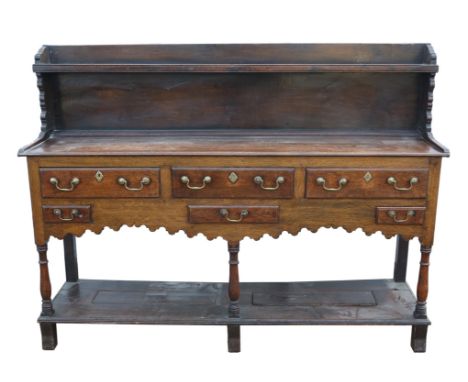 A George III oak dresser base, the shelf back reduced, with an arrangement of six drawers, H 114cm, W 153cm, D 40cm