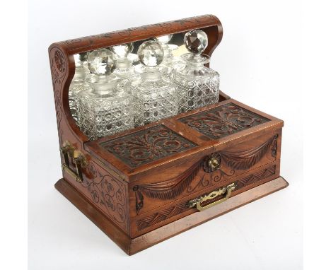 Edwardian mahogany carved tantalus games compendium, with Bramah lock to storage containers containing Bezique markers, the d