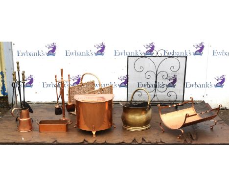 A group of copper, brass and wrought iron items, 20th century, to include two fire tool stands, a copper log basket, a bowed 