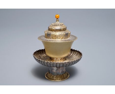 A Tibetan ritual jade bowl on parcel-gilt silver stand with amber finial, 19th C     H.: 17 cm         Condition reports and 
