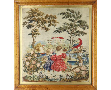 A large woolwork tapestry, 19th century, depicting two children to the foreground playing by a river with sailing boat, with 
