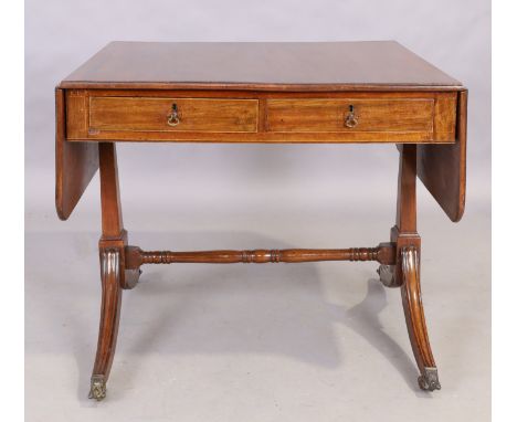A George III mahogany sofa table, first quarter 19th century, the frieze with two drawers on either side, on sabre legged tre