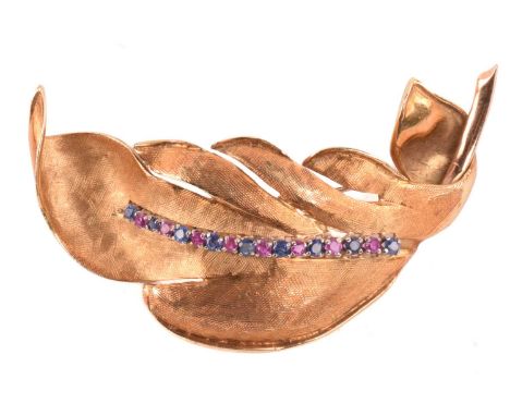 A ruby and sapphire feather brooch in textured gold, set with a row of alternating rubies and sapphires, the reverse stamped 
