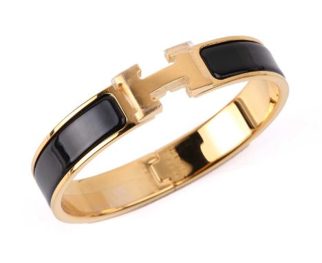 Hermès - A narrow 'Clic H' bracelet with black enamel and gold-tone metal, signed and marked, internal diameter measures 5.9 