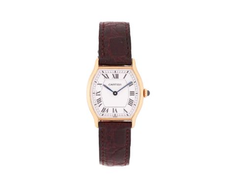 Cartier. An 18 carat gold Tortue watch. The white barrel shaped dial with Roman numerals and outer minute track; blued steel 