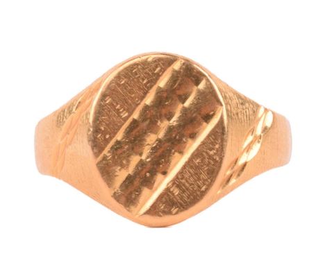 A 22ct yellow gold signet ring, the oval ring head with diagonal patterns, tapered shoulders with engraved details on forged 