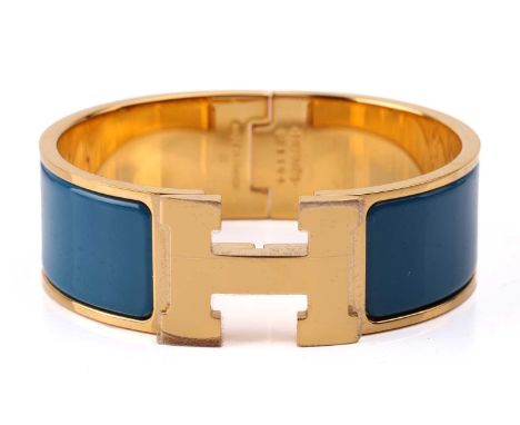 Hermès - A wide 'Clic H' bracelet with teal blue enamel and gold-tone metal, signed and marked, internal diameter measures 5.