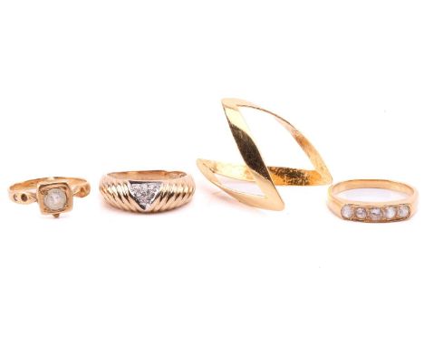 Four dress rings, to include a diamond-set ring with ribbed details, yellow metal testing 9ct, size M; a high carat chevron r