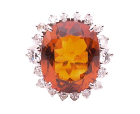 A citrine and diamond ring, set with a central cushion shape citrine measuring 17.9mm x 14.7mm x 9mm, surrounded by round bri