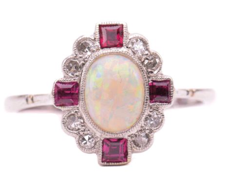 An Art Deco opal, ruby and diamond dress ring, features an oval cabochon of a translucent precious opal with good play-of-col