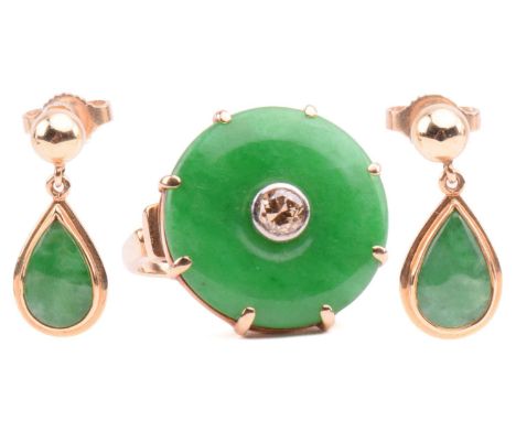 A jade and diamond dress ring; the circular jadeite bi disc of bright green colour, set with a central round brilliant-cut di