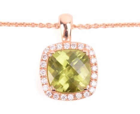 A peridot and diamond cluster pendant in 18ct gold, comprising a cushion-shaped chequerboard-cut peridot of vivid olive green