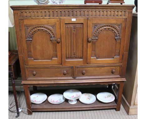 A reproduction carved oak cupboard with arched doors over two drawers with pot shelf base 130 x 120 cm&nbsp;